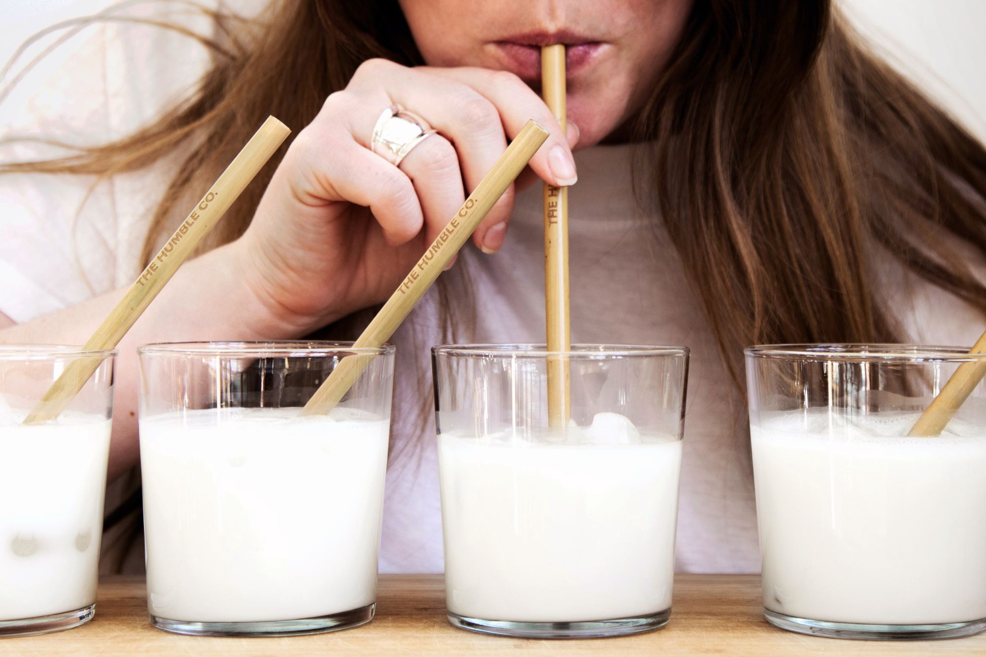 Woman drinking from bamboo straws