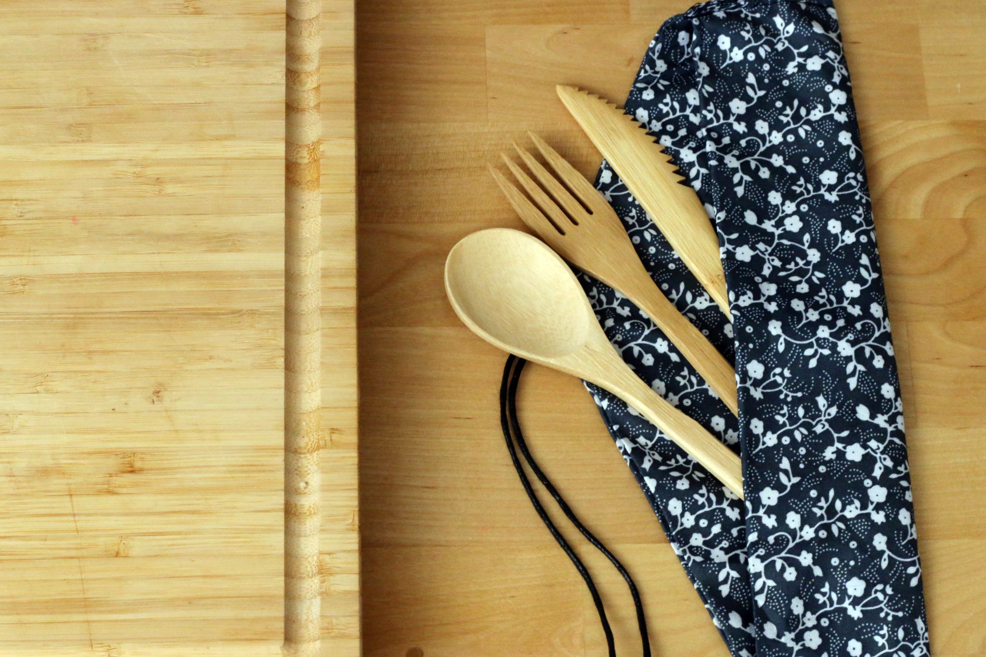Bamboo flatware cutlery next to a bamboo cutting board