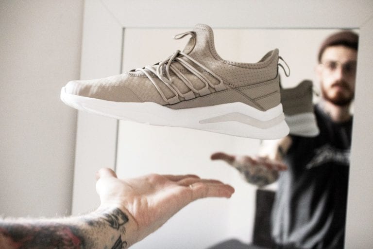Man looking at shoe; bamboo shoe racks